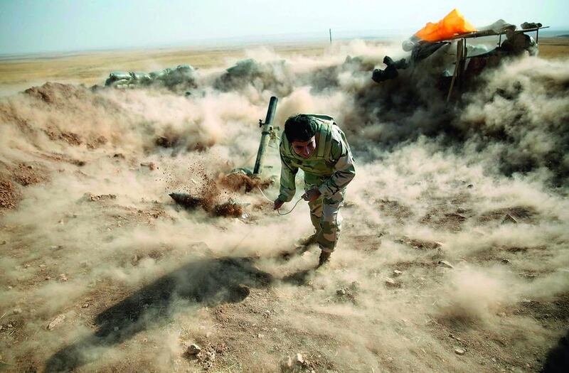 A Kurdish peshmerga fighter launching mortar shells towards Zummar, controlled by ISIL, near Mosul on September 15. Ahmed Jadallah / Reuters