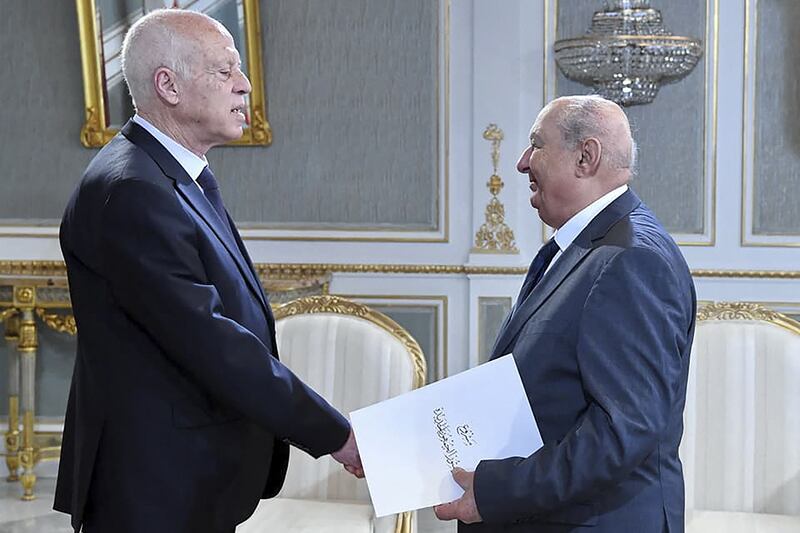 Sadok Belaid, head of Tunisia’s constitution committee, submits a draft of the new constitution to President Kais Saied at the Carthage Palace in Tunis. AFP