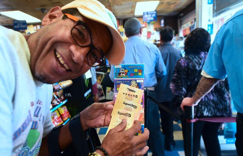 Berg Beteda shows his just purchased lottery tickets in Los Angeles, California on October 23, 2018, The Mega Millions jackpot, now reaching 1.6 billion USD, will be drawn tonight. / AFP / Frederic J. BROWN
