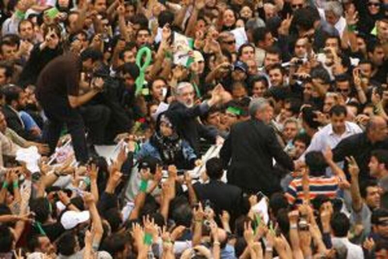 Mr Mousavi, centre right, and his wife Zahra Rahnavard, as they are surrounded by their supporters.