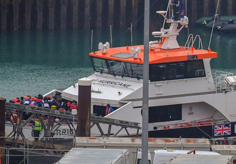 Migrants leave a British Border Force boat in Dover, England, on Monday after they were picked up in the English Channel. EPA