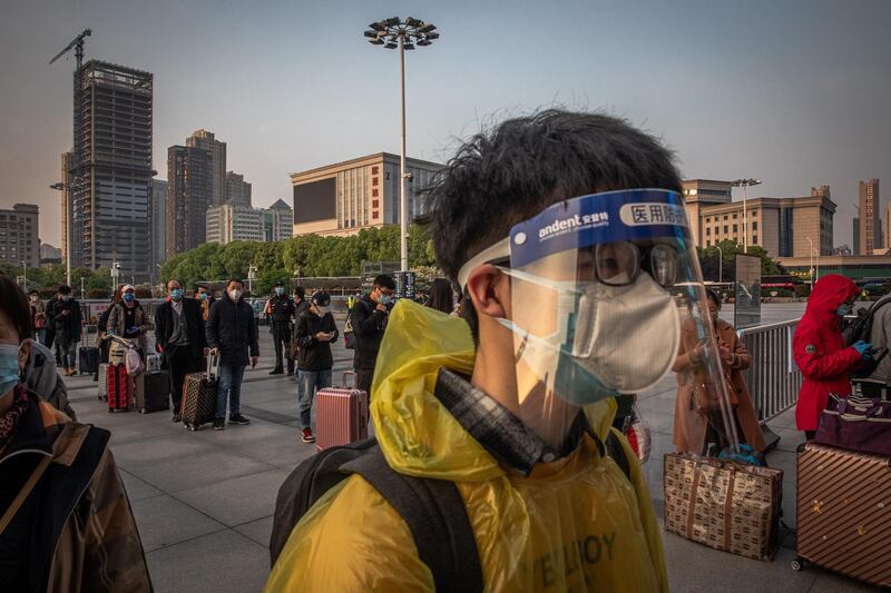 Passengers wait to enter the railway station  after the lockdown was lifted, in Wuhan.  EPA