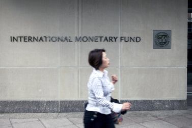 A woman walks past the International Monetary Fund (IMF) headquarters in Washington. The fund extended debt service relief to the 28 poorest countries until October this year and said further extensions could be made until April 2022 if enough money is raised. Bloomberg via Getty Images