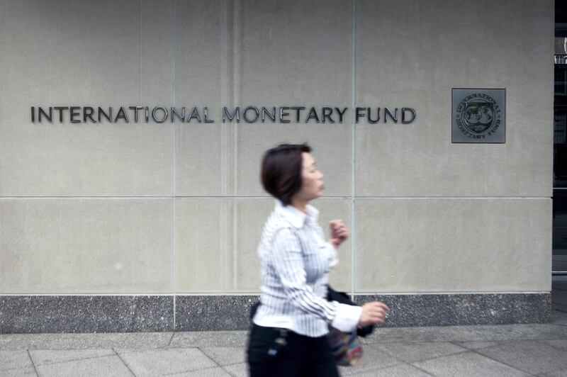 A woman walks past the International Monetary Fund (IMF) headquarters in Washington, D.C., U.S., on Monday, May 16, 2011. IMF chief Dominique Strauss-Kahn, accused of attempting to rape a hotel housekeeper, was ordered held without bail by a New York judge after prosecutors said he presented a flight risk. Photographer: Andrew Harrer/Bloomberg via Getty Images