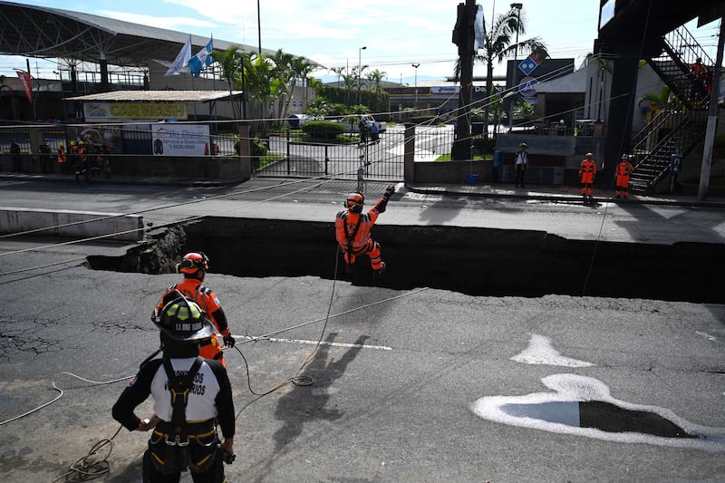 Rescue teams and members of the Guatemalan army entered the sinkhole to search for the two missing people.

