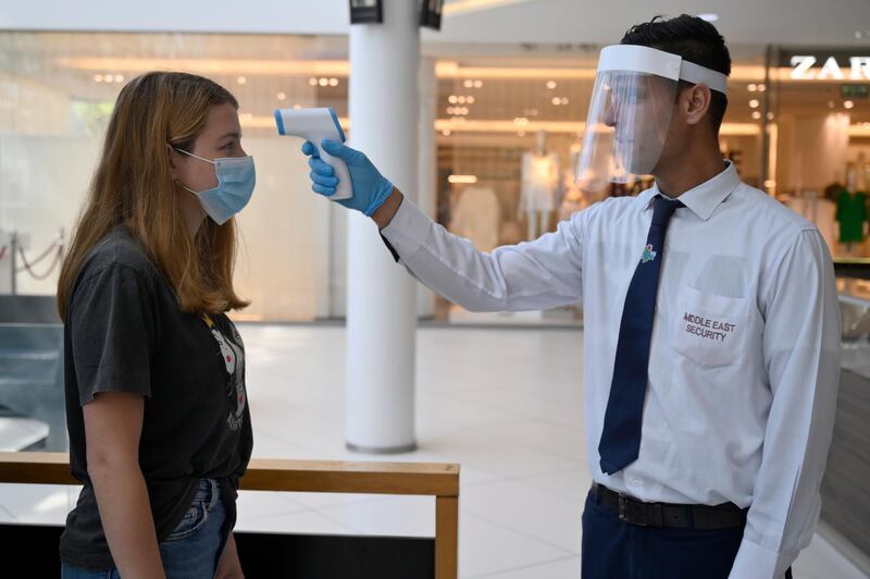 A security guard wearing a face mask checks the body temperature of a customer in a shopping mall in Dbayeh, northern Beirut, Lebanon.  EPA