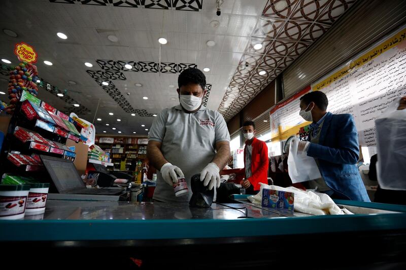 A supermarket employee wears a protective face mask as he works  in Sanaa, Yemen.  EPA