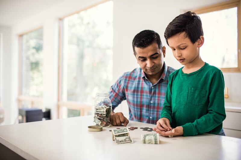 Father and son counting money at home