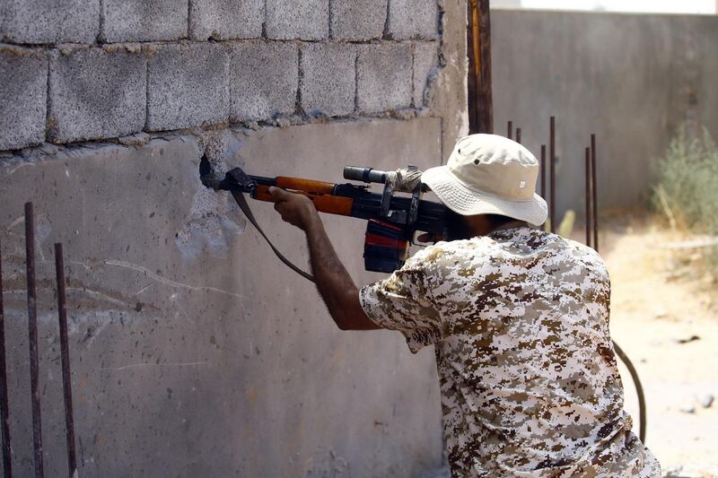 A fighter loyal to the internationally recognised Libyan Government of National Accord (GNA) fires trhough a hole in a wall during clashes with forces loyal to strongman Khalifa Haftar in the capital Tripoli's suburb of Ain Zara.  AFP