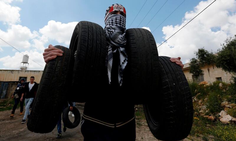 A protester carries tyres to burn during clashes in the occupied West Bank. AFP