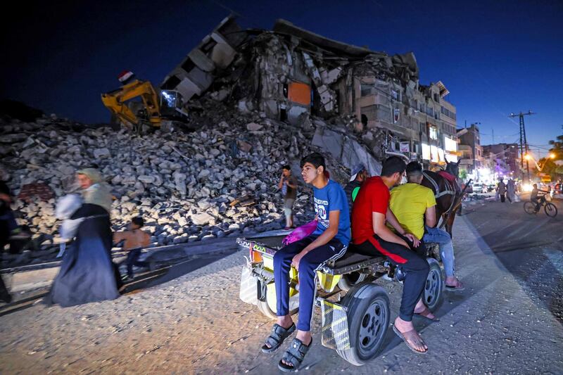 Palestinians pass by the destroyed Al Shuruq tower in Gaza City's Al Rimal neighbourhood. AFP