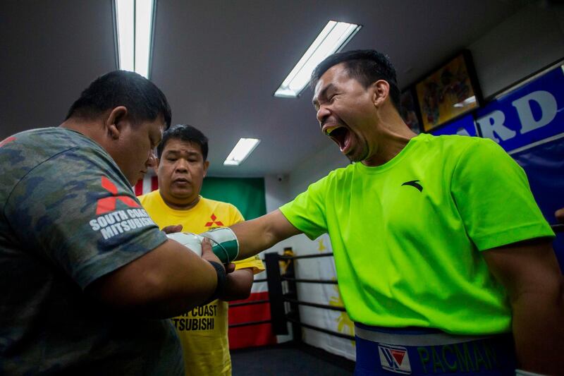 Manny Pacquiao gets his gloves put on before a training session at Wild Card Gym. AFP