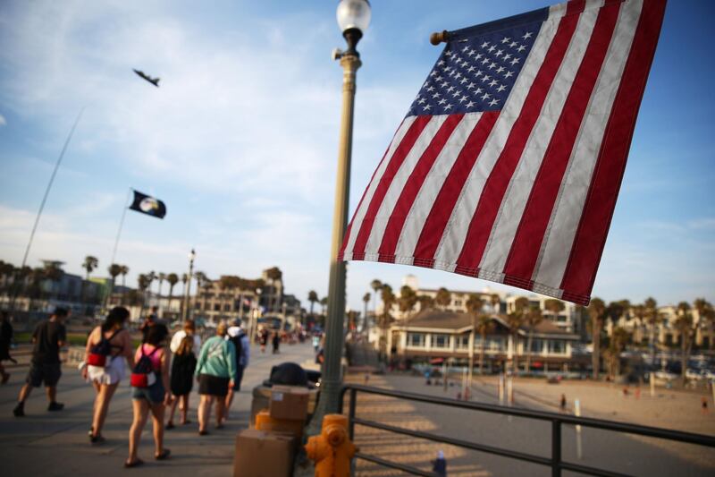HUNTINGTON BEACH, CALIFORNIA - JUNE 15: An American flag is displayed on the Huntington Beach pier on June 15, 2021 in Huntington Beach, California. California, the first state in the U.S. to go into lockdown at the beginning of the coronavirus pandemic, is lifting nearly all COVID-19 restrictions today with the exceptions of mask wearing and social distancing on public transportation, hospitals, K-12 schools indoors and some retail stores.   Mario Tama/Getty Images/AFP
== FOR NEWSPAPERS, INTERNET, TELCOS & TELEVISION USE ONLY ==
