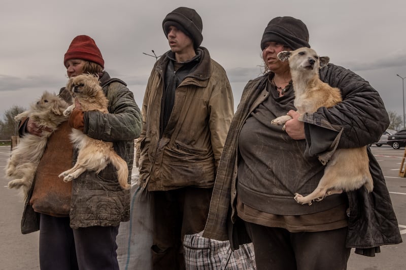 A family from Myrne, a town occupied by Russian forces, wait to register with police at an evacuation point for people fleeing from Mariupol, Melitopol and surrounding towns. Getty Images