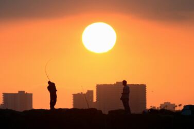 A fisherman casts his line from the rocks at Seal Beach, California, as the sun prepares to set. Frederic J. Brown / AFP 