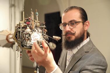 Mohamad Hafez with his suspended sculpture, ‘Hung Memories’, on show at Sharjah Art Museum.​​ Pawan Singh / The National