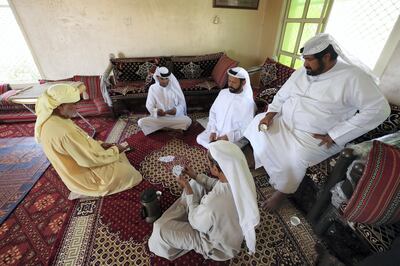 Ras Al Khaimah, United Arab Emirates - Reporter: Anna Zacharias: Race camel owners play cards. A Dutch poet scholar Marcel Kurpershoek (not in pic) visits Ras Al Khaimah in search of missing words used in the works of 17th century Ras Al Khaimah poet Ibn Dhaher, a renowned bard and folk hero. Sunday, March 1st, 2020. Ras Al Khaimah. Chris Whiteoak / The National
