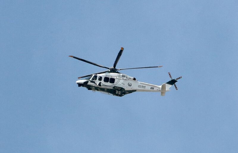 A Dubai Police helicopter circles the area.