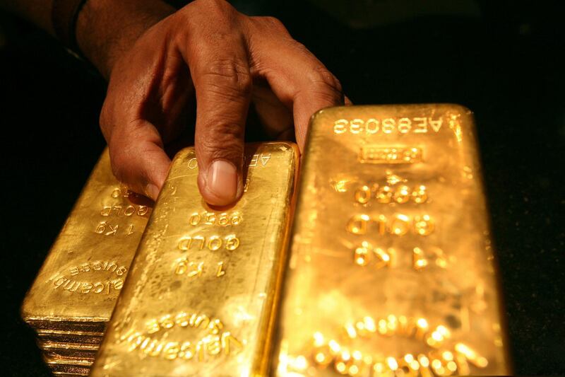 FILE PHOTO: A security guard places several one kilo gold bars inside a secured vault in Dubai April 20, 2006./File Photo