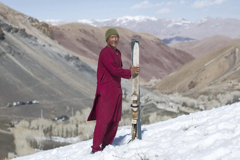 AFGHANISTAN, Bamiyan: 04 March 2021
Pictures from the annual Afghan Mountain Challenge - a ski event held in Bamiyan Province, 80 miles west of Kabul. Participants have to run up the mountain via specific checkpoints and then proceed to ski down. 
Pictured - Nasrullah 16 stands for a picture after the wooden ski race. Rick Findler for The National