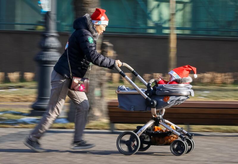 A reveller wearing a festive hat runs with a pram during a parade to celebrate the upcoming Christmas and New Year in Almaty, Kazakhstan. Shamil Zhumatov / Reuters