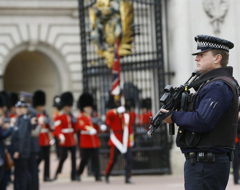 An armed police officer keeps guard outside Buckingham Palace in London, UK. Kirsty Wigglesworth / AP Photo