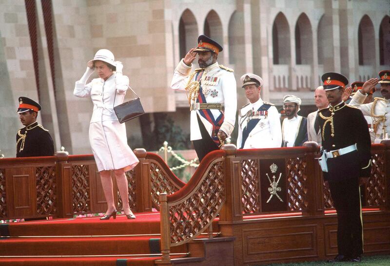 OMAN - FEBRUARY 28:  The Queen With Sultan Qaboos In Oman.  During The Arrival Ceremony At Sultan Qaboos' S Home Muscat Palace. She Is Holding Onto Her Hat After It Had Been Knocked Off By The Wind  (day Date Not Certain. Gulf Tour Dates 12 Feb - 1 March 1979)  (Photo by Tim Graham Photo Library via Getty Images)