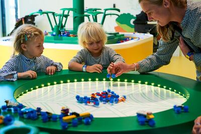 Children play at the 'crittocreator' at Lego House in Billund, Denmark. Lego House