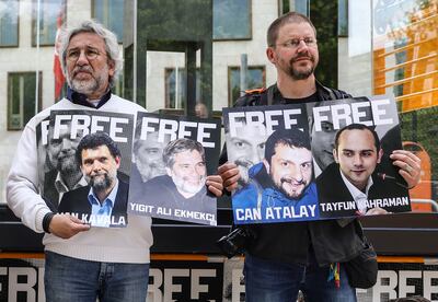 Protesters in Berlin display the images of activists jailed by Turkey, including Osman Kavala. Getty