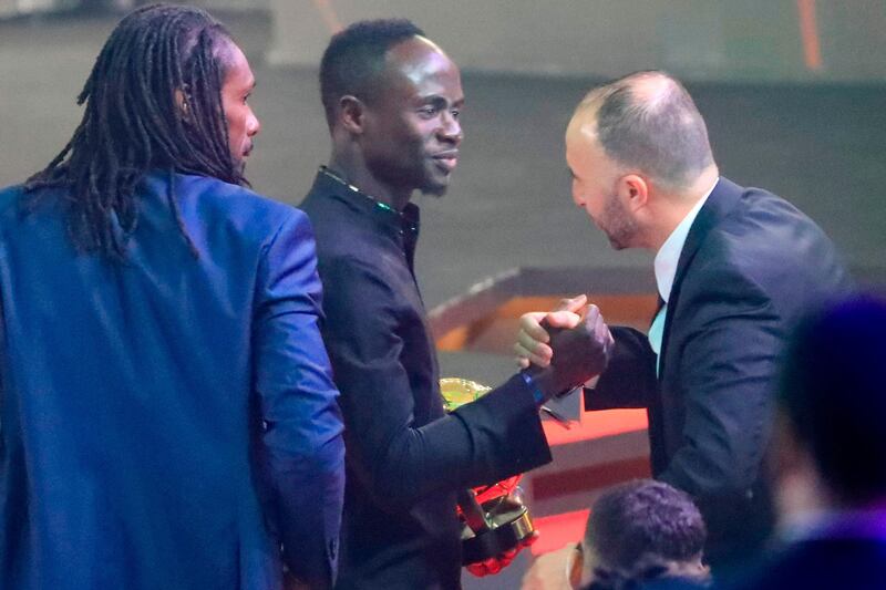 Senegal winger Sadio Mane (C) is congratulated by Algeria's Djamel Belmadi (R), Coach of the Year winner, and Senegalese football coach Aliou Cisse. AFP