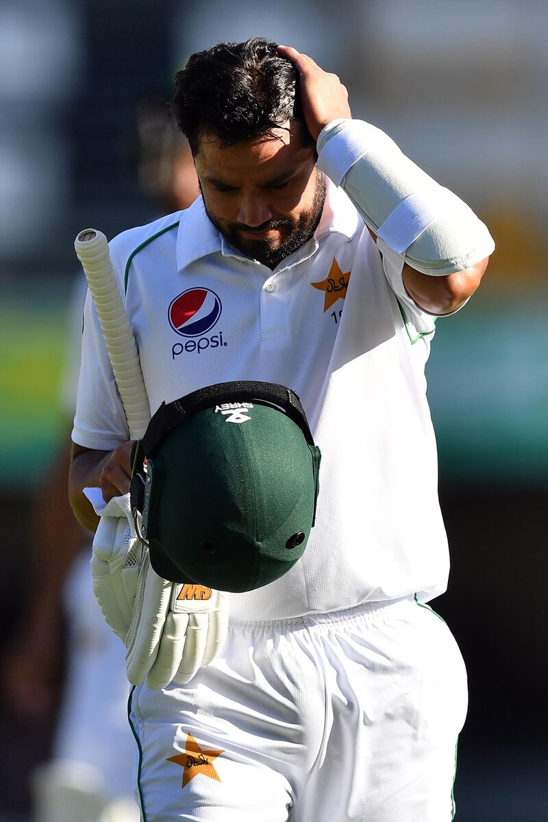 Pakistan's batsman Azhar Ali walks back to the pavilion after his dismissal off Australia's paceman Mitchell Starc on day three of the first Test. AFP