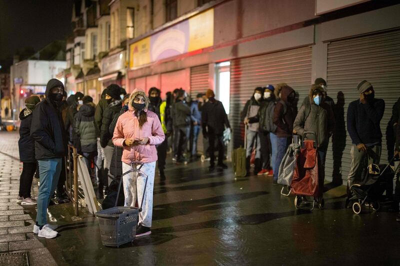 Despite the rain, dozens of young people, hoods on their heads and shopping bags in their hands, congregate in front of the small room of the Newham Community Project association, in East London. AFP