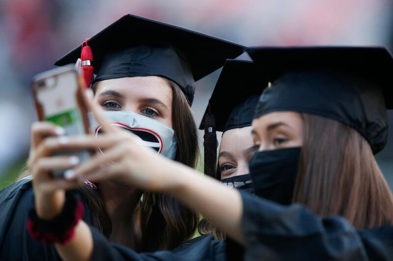 Graduates take a selfie before the start of the University of Georgia's rescheduled Spring Commencement at Sanford Stadium in Athens, Ga., Friday, Oct. 16, 2020. The ceremony was moved from the spring due to the ongoing COVID-19 pandemic. (Joshua L. Jones/Athens Banner-Herald via AP)