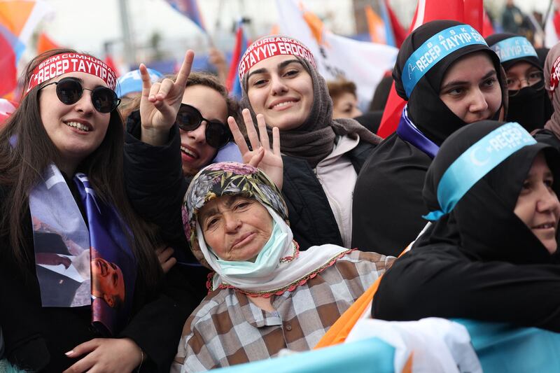 Erdogan supporters smile at the campaign rally. AFP
