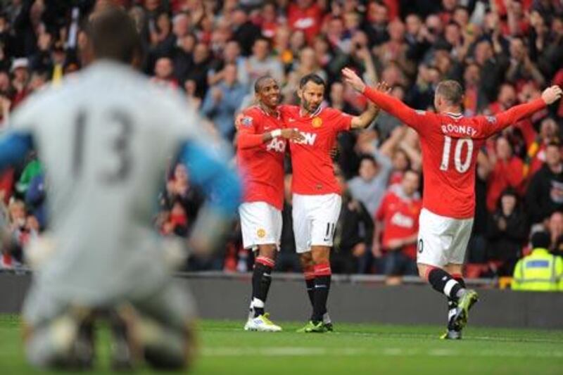 Manchester United's Ashley Young, left, celebrates with teammates, Ryan Giggs and Wayne Rooney, right, after scoring their eighth goal as they beat Arsenal 8-2 in August.