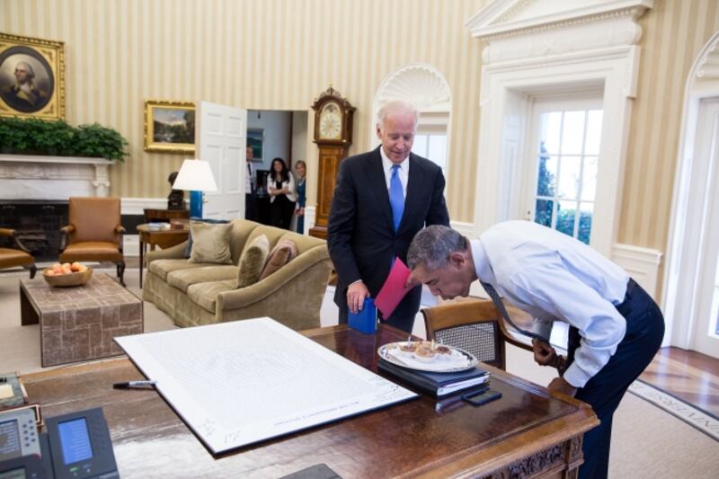 Then-president Barack Obama blows out candles on birthday cupcakes brought to him by then-vice president Joe Biden at the White House in 2016. Photo: National Archives / Pete Souza