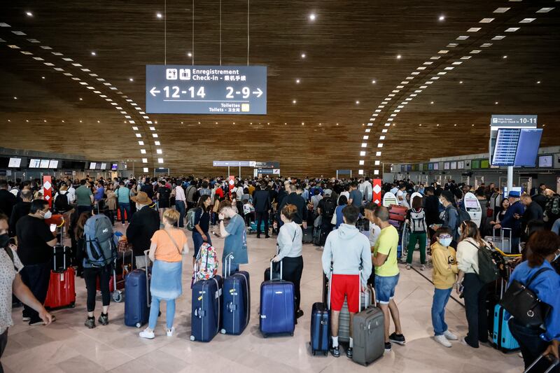 Passengers wait to check in at Charles de Gaulle airport, north of Paris. Flights from French airports faced disruptions on Friday as airport workers went on strike. AP