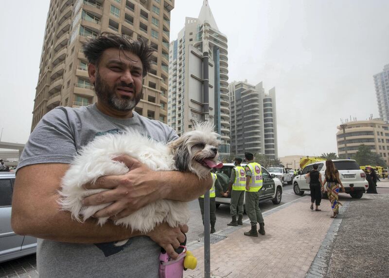 DUBAI, UNITED ARAB EMIRATES 13 MAY 2018 -A residence from the  burning Zen Tower  with his dog in Marina, Dubai. Leslie Pableo for The National