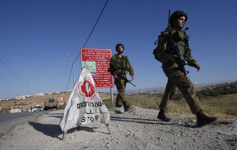 Israeli soldiers at a temporary checkpoint in the occupied West Bank. Hazem Bader / AFP