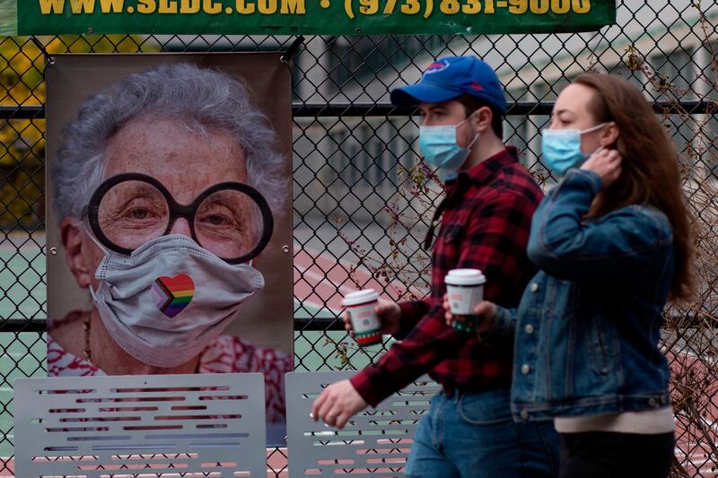 People walk past a picture by AJ Stetson, part of his "Masked NYC" exhibition, on the Upper West Side area of Manhattan New York.  AFP