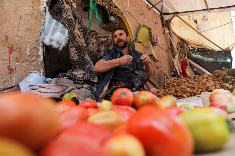 A vendor waits for customers at his vegetable stall.