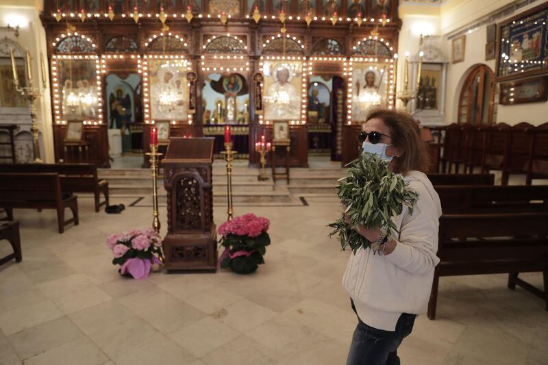 A Lebanese woman wearing a protective mask amid the COVID-19 pandemic takes part in Palm Sunday celebrations for Orthodox Christians at a church in the Ashrafiyeh district of the capital Beirut.  AFP