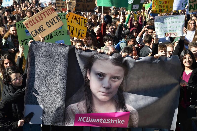 - AFP PICTURES OF THE YEAR 2019 -

People and students hold placards and a banner showing 16-year-old Swedish political activist Greta Thunberg, who seeks to stop global warming and climate change, as they take part in a protest against global warming in central Rome on March 15, 2019.  - 
 / AFP / Andreas SOLARO
