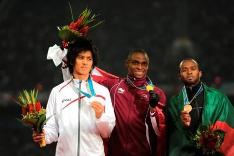 Femi Seun Ogunode of Qatar (C) poses on the podium with Kenji Fujimitsu of Japan (L) and Omar Juma al-Salfa of the United Arab Emirates (R) during the award ceremony for the men's 200m in the athletics competition at the 16th Asian Games in Guangzhou on November 25, 2010. Femi Seun Ogunode of Qatar won gold, Kenji Fujimitsu of Japan won silver and Omar Juma al-Salfa of the United Arab Emirates took bronze.  AFP PHOTO / PETER PARKS
 *** Local Caption ***  740955-01-08.jpg