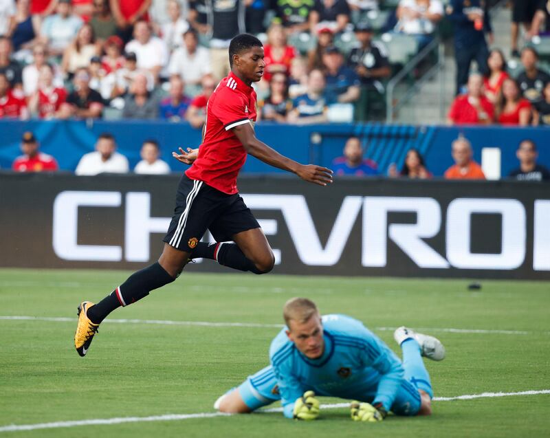 Manchester United's Marcus Rashford, top, runs past Los Angeles Galaxy goalkeeper Jon Kempin after scoring a goal during the first half of a friendly soccer match Saturday, July 15, 2017, in Carson, Calif. (AP Photo/Jae C. Hong)
