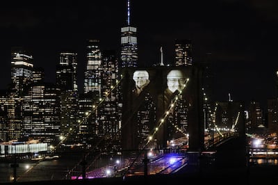 NEW YORK, NY - MARCH 14: Faces of victims of COVID-19 are projected onto the Brooklyn Bridge during a memorial service called â€œA COVID-19 Day of Remembranceâ€ on March 14, 2021 in New York City. The event, which will include a virtual performance by The New York Philharmonic, marks the day the first known coronavirus fatality was confirmed in the city.   Spencer Platt/Getty Images/AFP (Photo by SPENCER PLATT / GETTY IMAGES NORTH AMERICA / Getty Images via AFP)