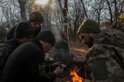 Ukrainian soldiers of an artillery unit have a rest near the bonfire on November 8. AFP