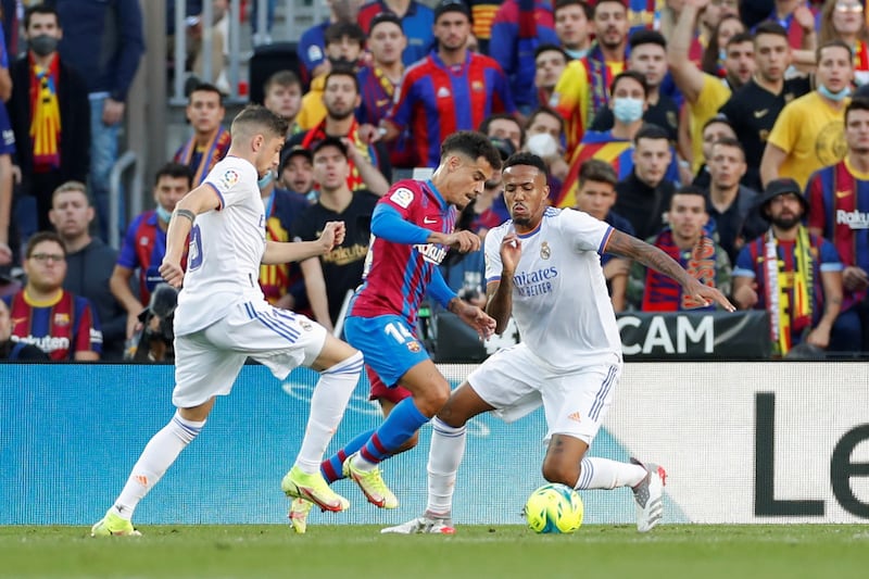 Barcelona midfielder Philippe Coutinho battles with Real Madrid defender Eder Militao. EPA