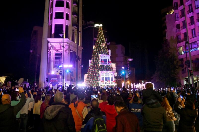 Lebanese people gather next to a giant Christmas tree which has been officially lit up at the Ashrafieh area in Beirut. EPA