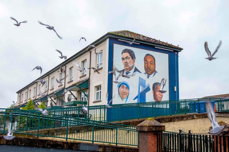 Pigeons fly past a mural depicting John Hume and other Nobel laureates, Martin Luther King Jr, Mother Teresa and Nelson Mandela in Derry, Northern Ireland. AFP